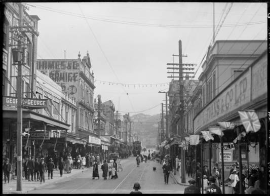 Looking up Cuba Street from the corner of Garrett Street c1920s. Part of no. 161-163 is visible at the front right, with the sign for George and George above the verandah.  National Library reference: Cuba Street, Wellington. Smith, Sydney Charles, 1888-1972 :Photographs of New Zealand. Ref: 1/2-048557-G. Alexander Turnbull Library, Wellington, New Zealand. http://natlib.govt.nz/records/22707136