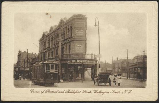 c.1911-1914 - Postcard showing the wedge-shaped building on the corner of Riddiford and Rintoul Streets, housing the Langham Private Hotel, and a Dominion branch office attached to the premises of E Back & Company. National Library reference:  Tanner Brothers Ltd (Publishers). [Postcard]. Corner of Rintoul and Riddiford Streets, Wellington South, N.Z. Published by Tanner Bros., Ltd., Wellington, Auckland and London. Printed in Saxony. [ca 1911-1914]. [Postcard album of cards collected by Joye Eggers / Taylor. 1905-1970s].. Ref: Eph-B-POSTCARD-Vol-8-049-3. Alexander Turnbull Library, Wellington, New Zealand. http://natlib.govt.nz/records/23048710